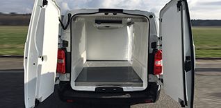 Bílý užitkový vůz Toyota Proace s otevřenou nákladovou plošinou, pohled zepředu.
