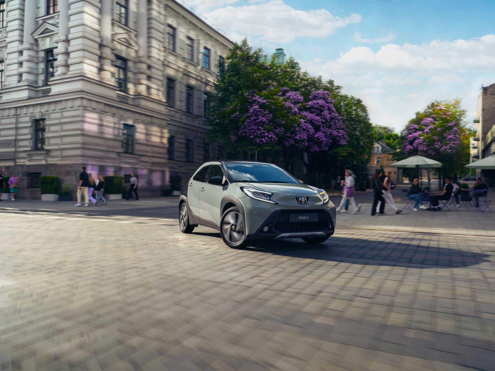 Aygo X cornering with agility in a sunlit city square