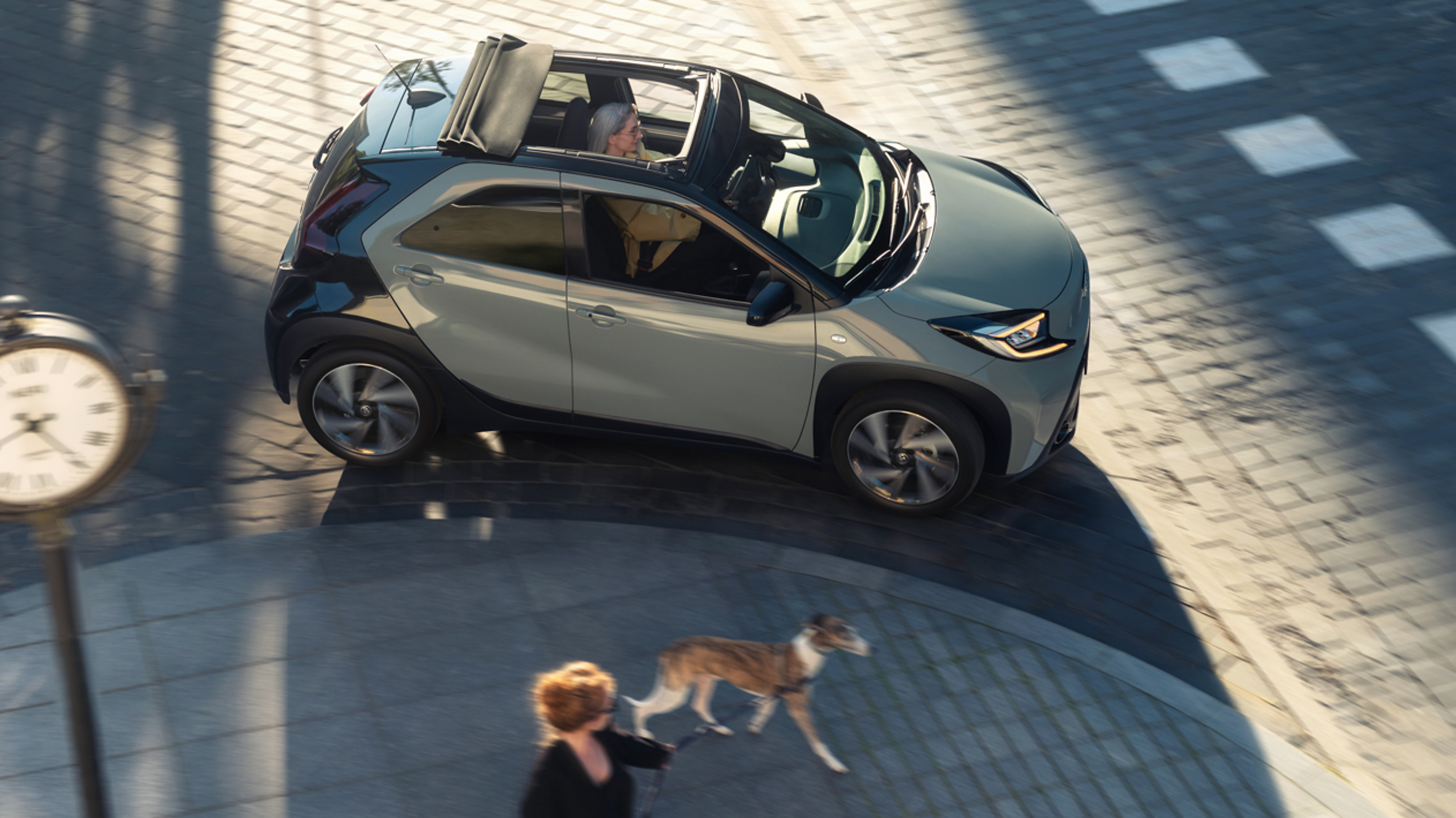 Femme devant une Aygo X JBL