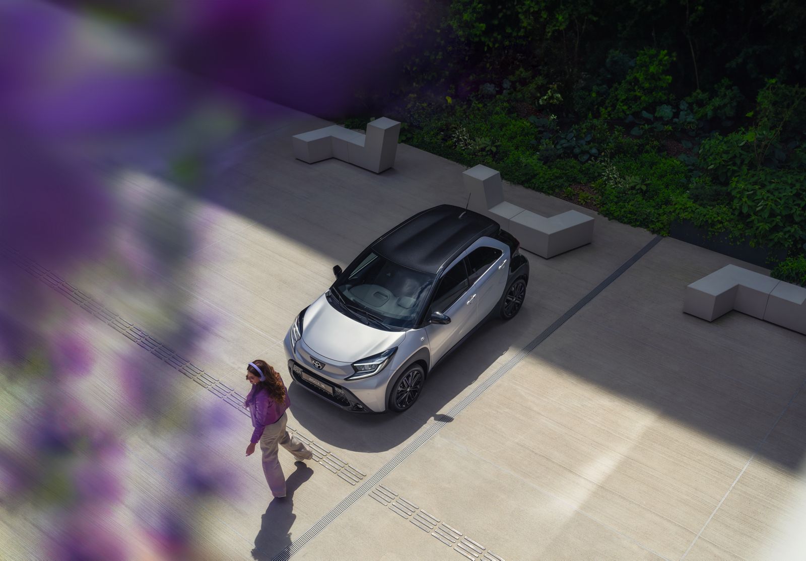 A woman walking towards her Aygo X
