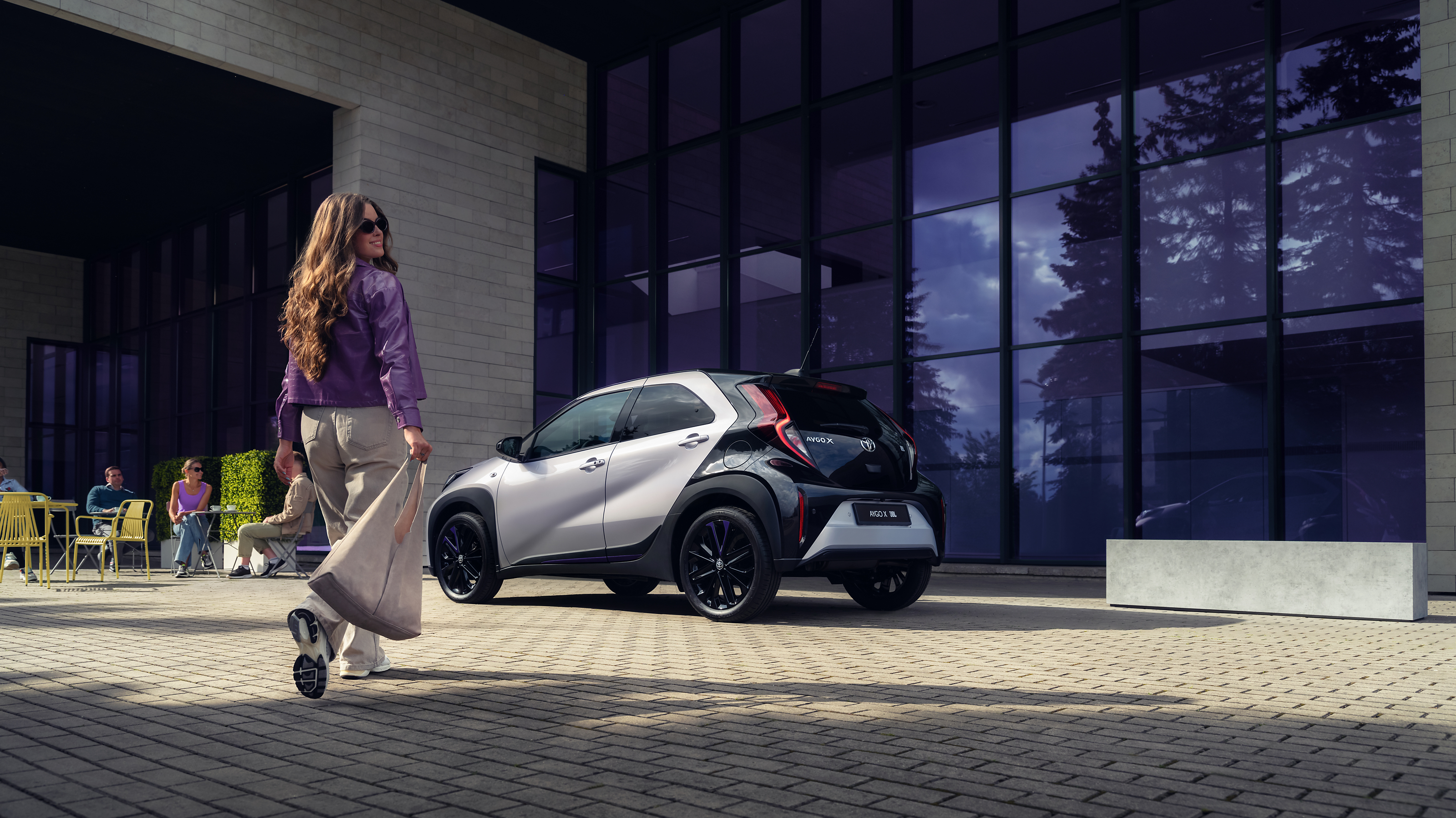 паркиран Aygo X и жена на преден план