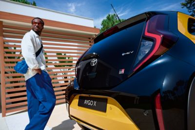 Toyota Aygo X Hybrid with man walking past