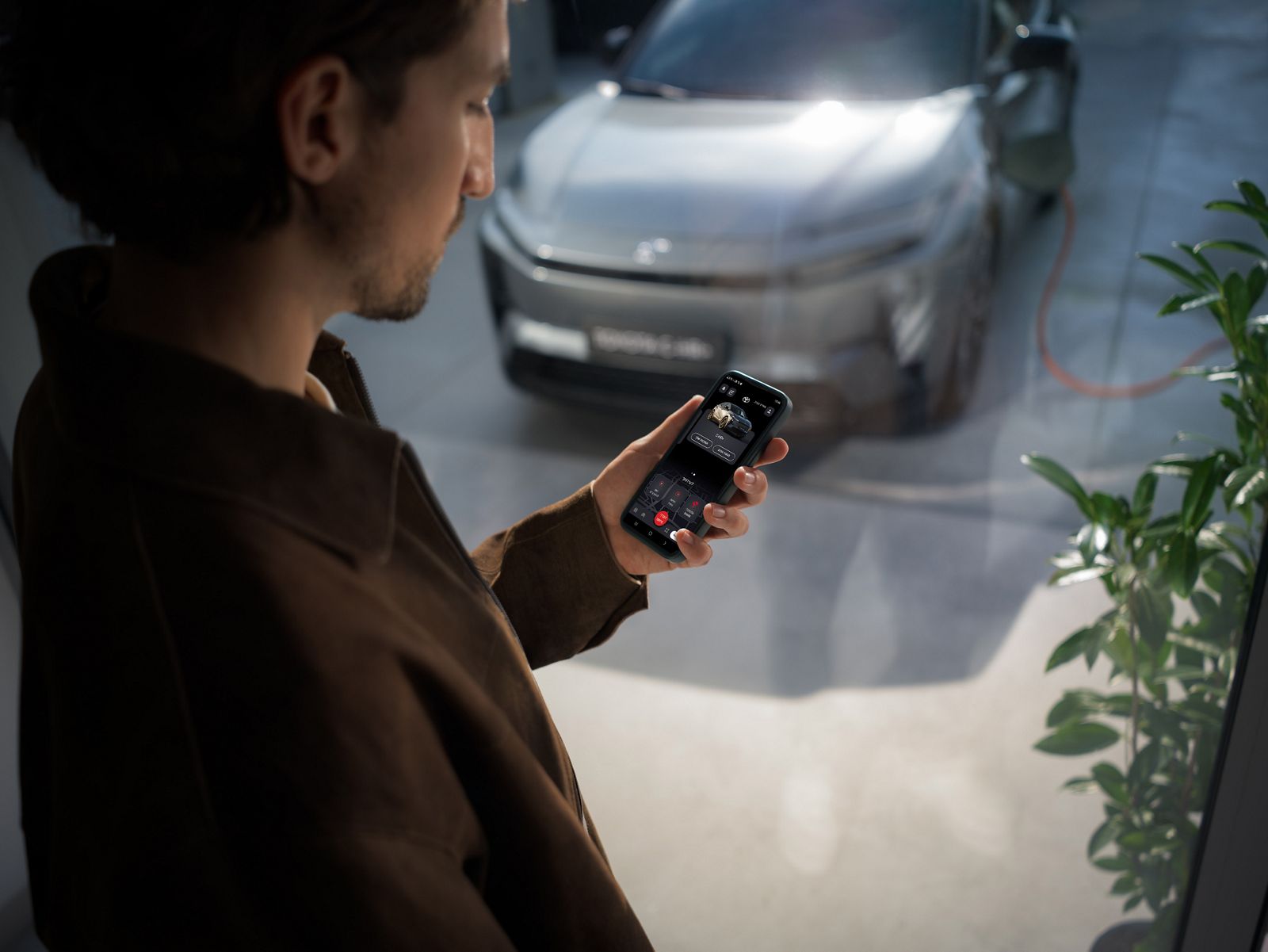 TOYOTA C-HR+ driver checking the MyToyota app on their phone