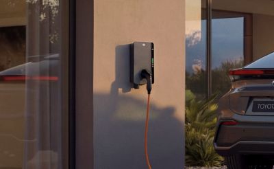 Eine Toyota Wallbox ist an der Außenwand eines modernen Wohnhauses installiert.
