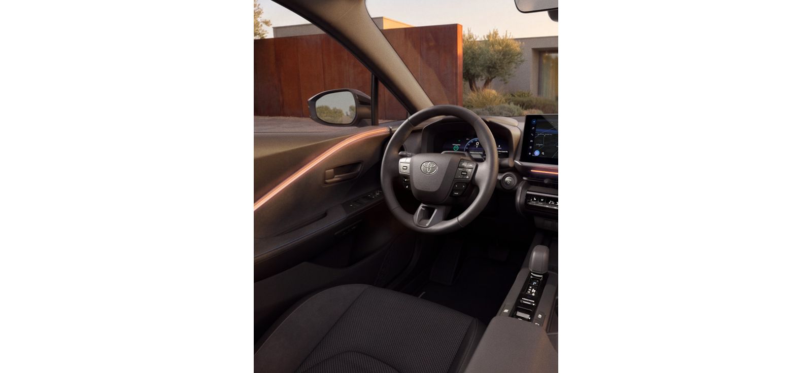 Innenraum des Toyota C-HR mit digitalem Cockpit, Multifunktionslenkrad und Blick auf ein modernes Wohnhaus.