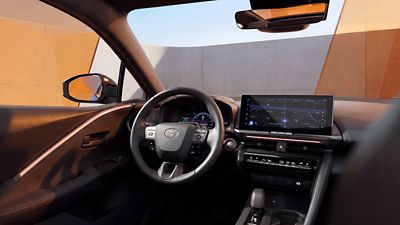 Innenraum des Toyota C-HR mit Lenkrad, digitalem Kombiinstrument und großem mittig angeordnetem Touchscreen auf dem Armaturenbrett