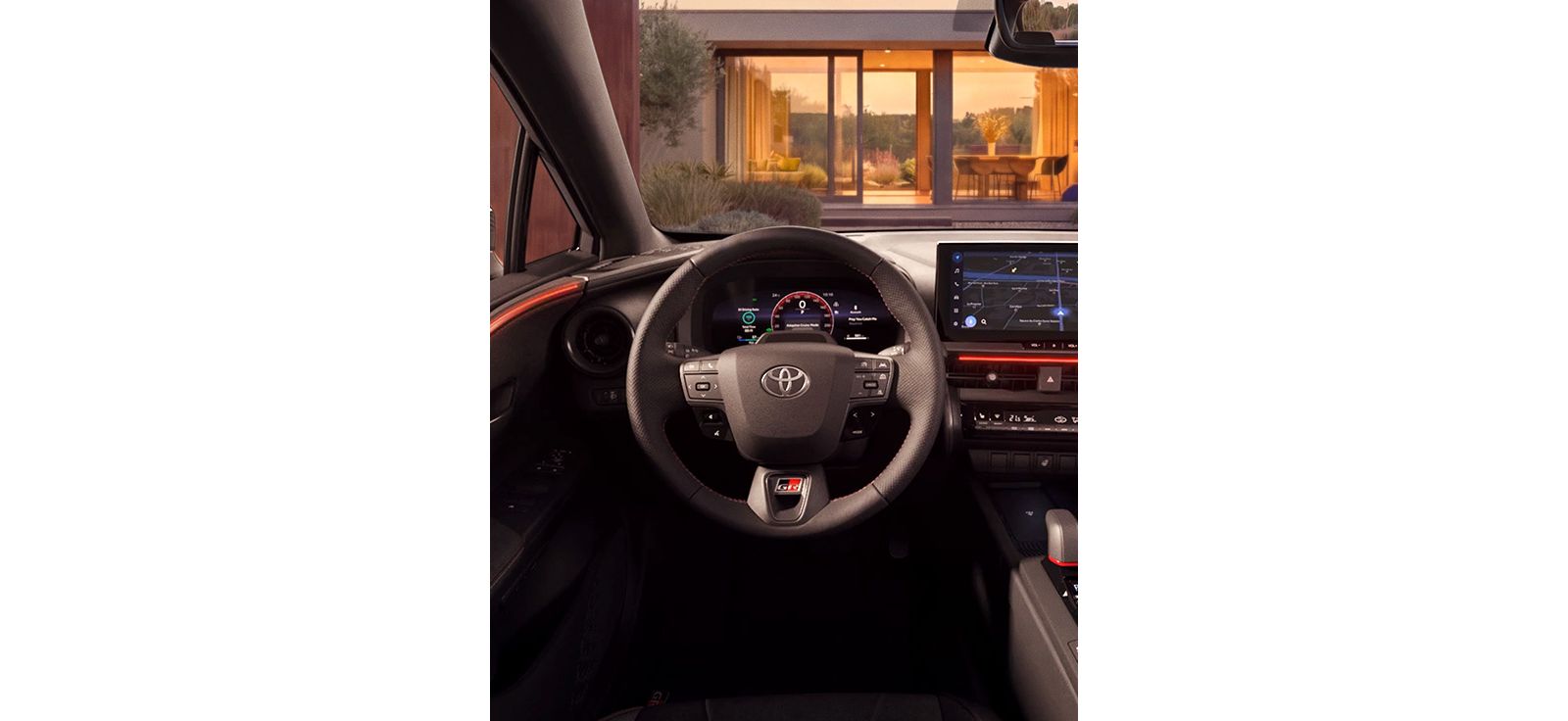 Innenraum des Toyota C-HR mit digitalem Cockpit, Multifunktionslenkrad und Blick auf ein modernes Wohnhaus.