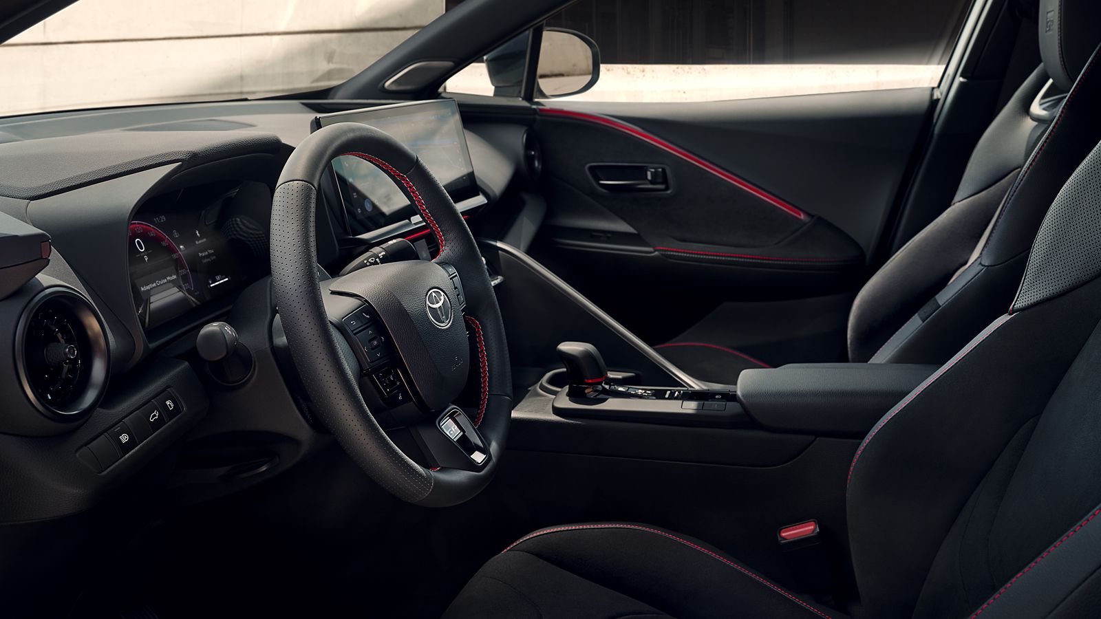 Kapıyı açarak Toyota C-HR’nin geniş iç mekânına bakan turuncu elbiseli kadın ve şık tasarım detayları