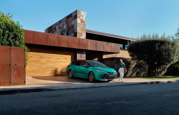 Toyota Corolla Touring Sports green with woman in driveway