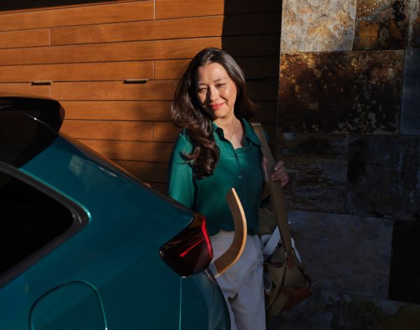 woman standing next to a Corolla Touring Sport