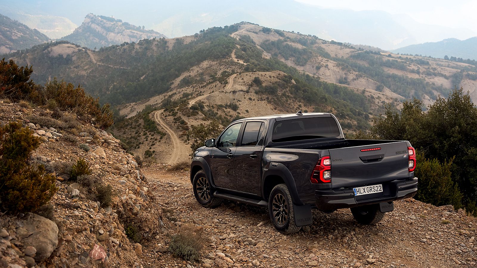 Toyota Hilux fährt einen steinigen Berg herunter auf felsigem Untergrund