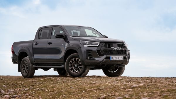 Grauer Toyota Hilux steht seitlich auf einem Hügel