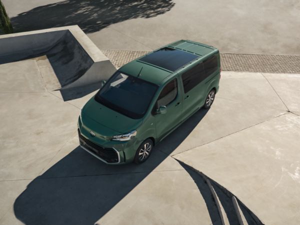 Vogelperspektive eines grünen Toyota Proace Verso, der auf einer offenen Freifläche aus Beton steht.