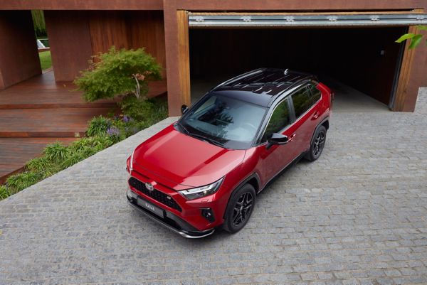Şehir içinde kavşaktan geçen beyaz RAV4 Hybrid