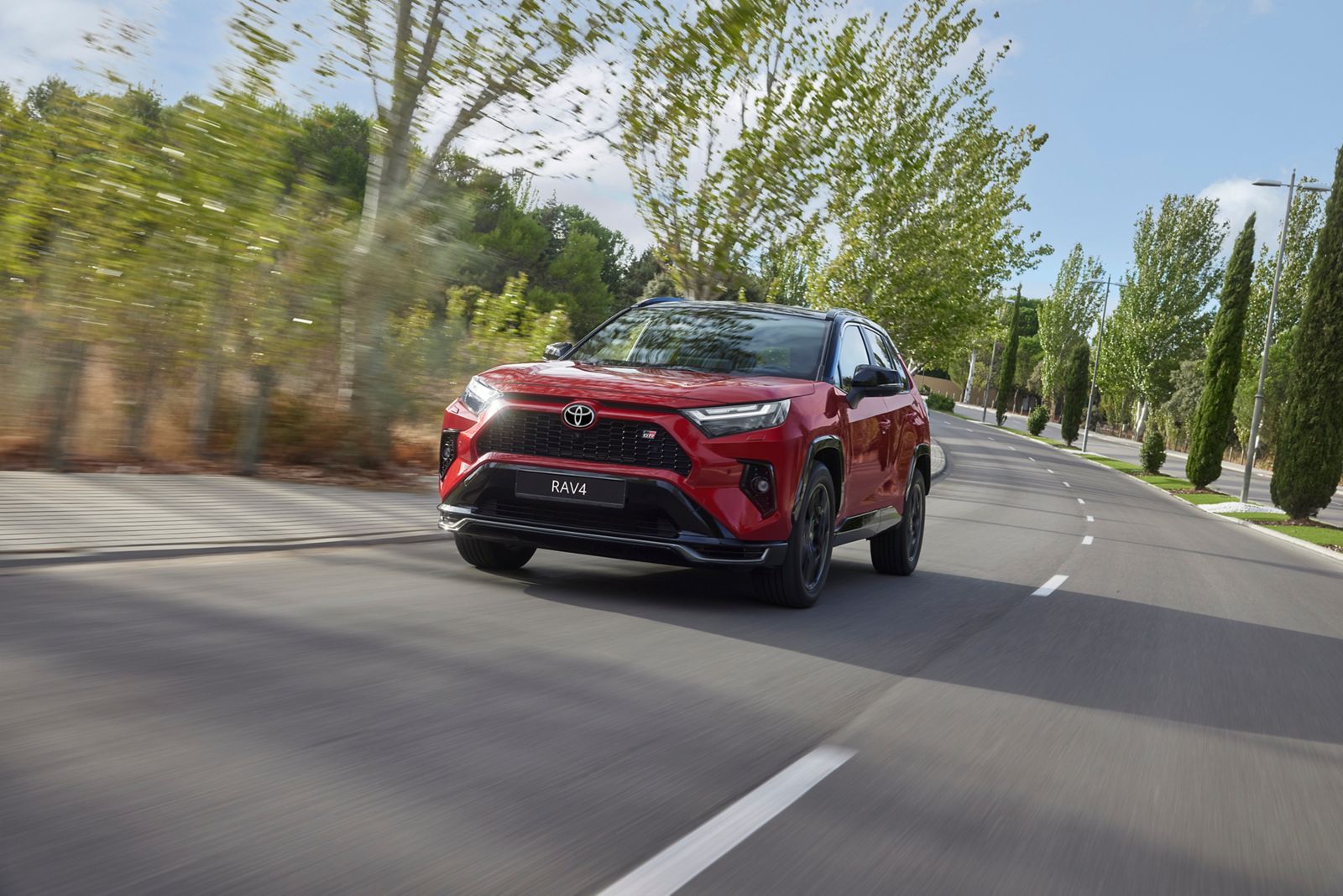 A Toyota RAV4 drives city streets in the dark and the rain  