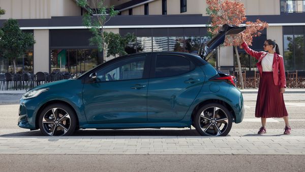 Toyota Yaris zijaanzicht geparkeerd aan de straat met achterklep open