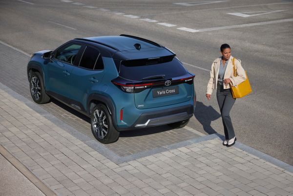 Eine Frau verlässt ihren Firmenwagen und geht Richtung Büro, zufrieden mit dem effizienten Verbrauch und den überschaubaren monatlichen Kosten ihres Dienstwagens in Österreich.