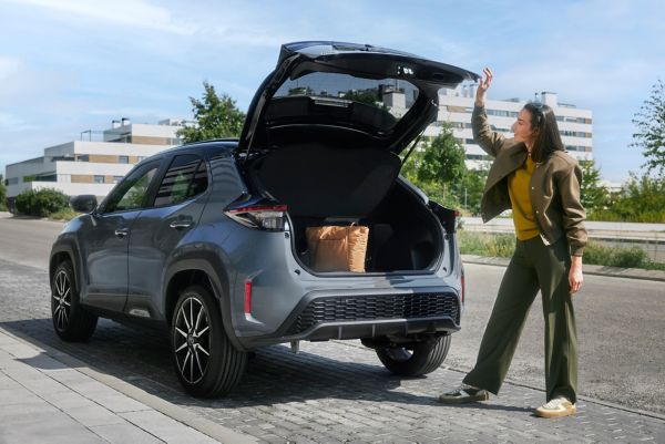 Vrouw staat op het punt om de laadklep van haar Yaris Cross te sluiten