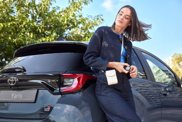 Woman sitting next to Toyota Yaris