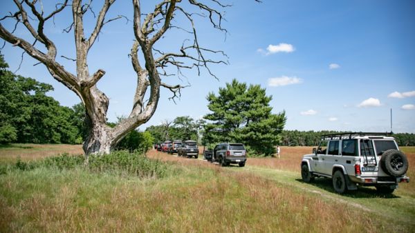 Toyoty Land Cruiser przejeżdżające przez polną drogę