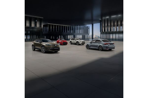 Nowoczesny salon Toyoty z czterema modelami: Toyota C-HR, Yaris, RAV4 i Corolla na tle panoramicznych okien z widokiem na miasto