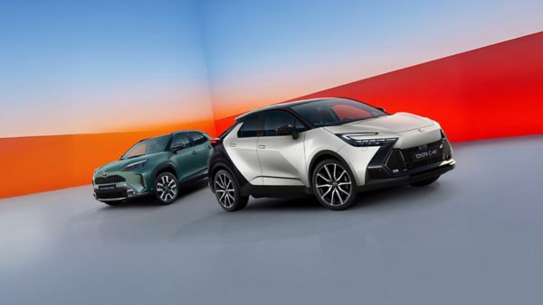 Toyota Yaris Cross i Toyota C-HR ustawione obok siebie w studiu na niebiesko-czerwonym tle