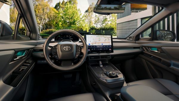 Wnętrze Toyoty z cyfrowym zestawem wskaźników, ekranem nawigacji i kierownicą z logo Toyota