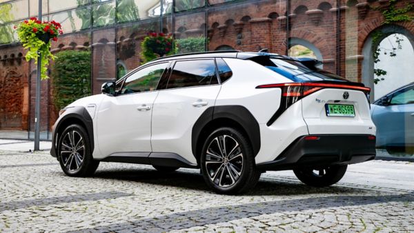 Toyota bZ4X zaparkowana w brukowanej uliczce na tle ceglanego budynku