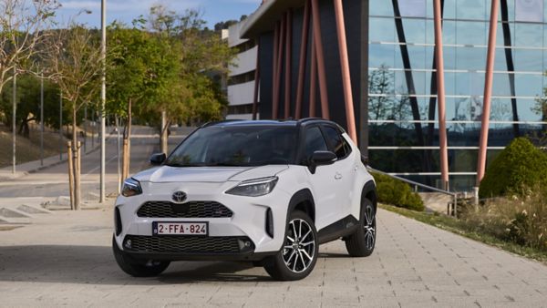 Zaparkowana Toyota Yaris Cross na tle szklanego budynku