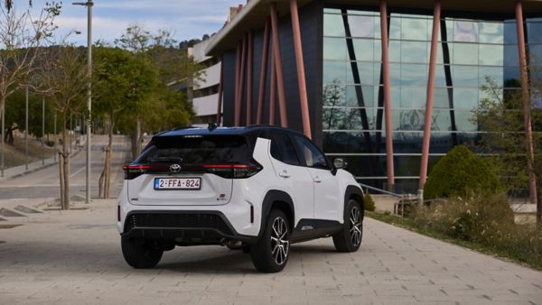 Zaparkowana tyłem Toyota Yaris Cross na tle szklanego budynku