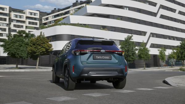 Zdjęcie zaparkowanej tyłem Toyota Yaris Cross na tle białego budynku