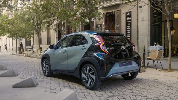 Zaparkowana tyłem Toyota Aygo X na tle staromiejskich zabudowań