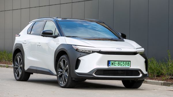 Zaparkowana Toyota bZ4X na tle budynku
