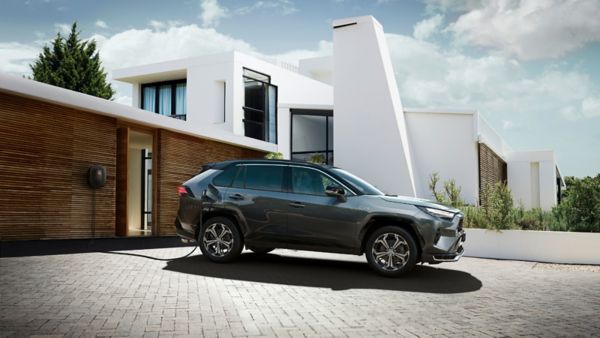 Toyota RAV4 Plug-in Hybrid zaparkowana obok garażu