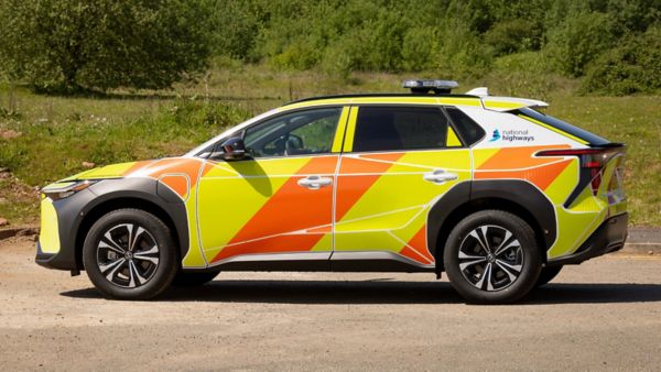 Toyota bZ4X w malowaniu National Highways na tle drzew