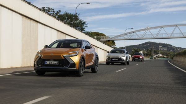 Trzy Toyoty C-HR podążające dwupasmową drogą