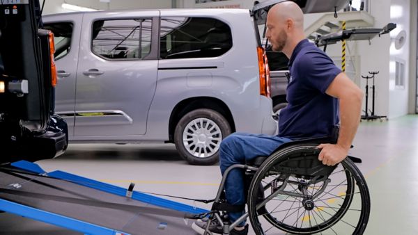 Mężczyzna na wózku inwalidzkim wjeżdżający po podjeździe do Toyoty PROACE 