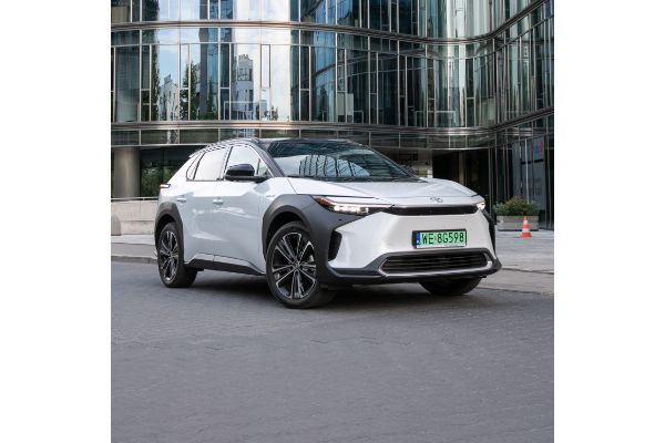 Toyota bZ4X zaparkowana na tle szklanego budynku