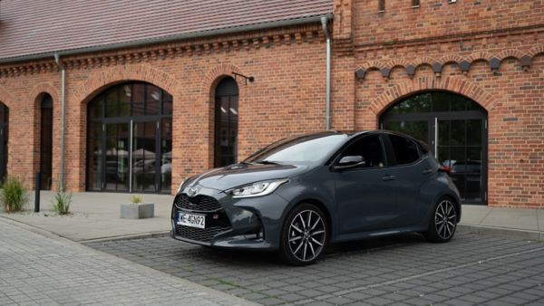 Toyota Yaris zaparkowana na tle ceglanego budynku