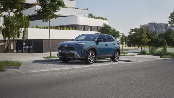 Toyota Yaris Cross zaparkowana na tle białego budynku