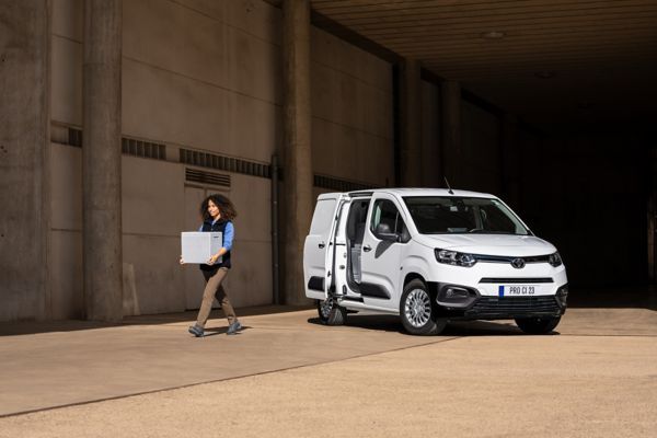 Woman carrying box out of cargo area of Toyota Proace