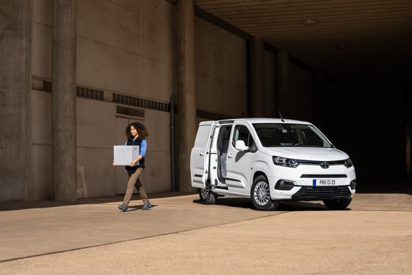 Woman carrying box out of cargo area of Toyota Proace