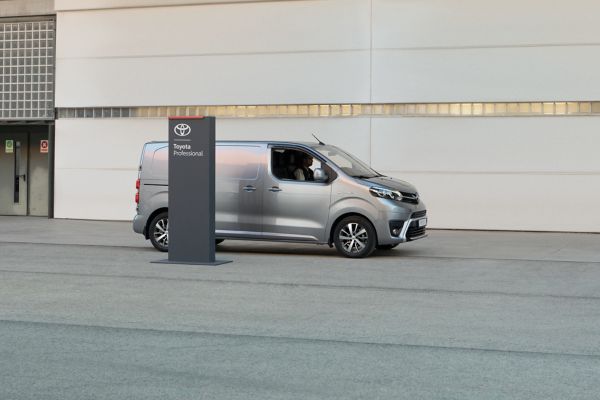 Toyota Proace steht hinter einer Säule vor einem Toyota Autohaus