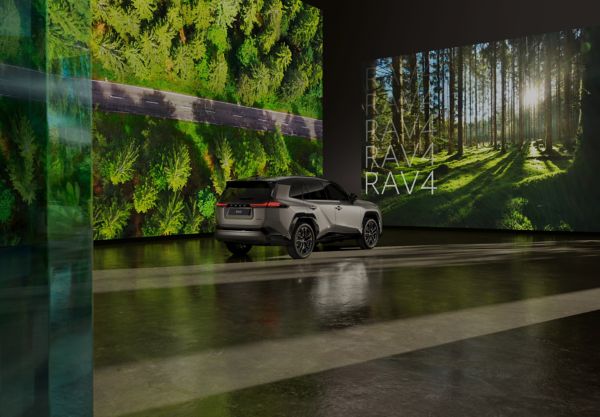 RAV4 Plug-in Hybrid parked infront of screens showing forest images