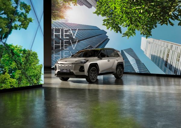 RAV4 Hybride garé devant un écran montrant des gratte-ciel