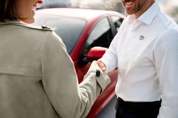 two people shaking hands at a Toyota dealership