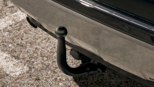 Nahaufnahme der Rückansicht eines silbernen Toyota RAV4 Hybrid in einer Parkbucht. Die Rücklichter, das Hybrid-Emblem und die Anhängerkupplung sind sichtbar.