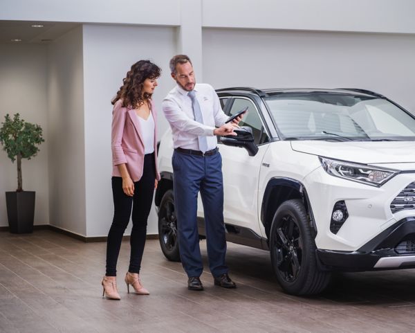 Toyota employee with a customer looking at a car