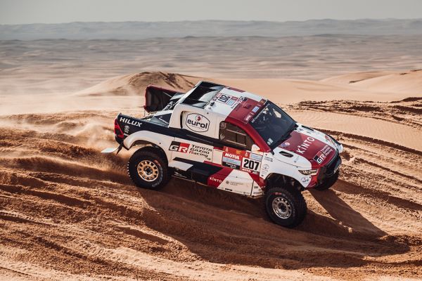 Rally car driving over a dune