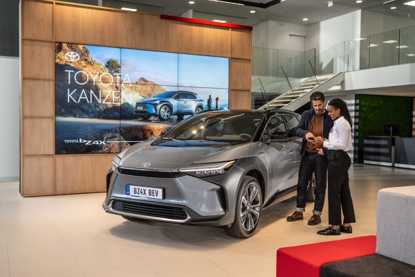 Toyota customer tapping a tablet in front of a Toyota bZ4X